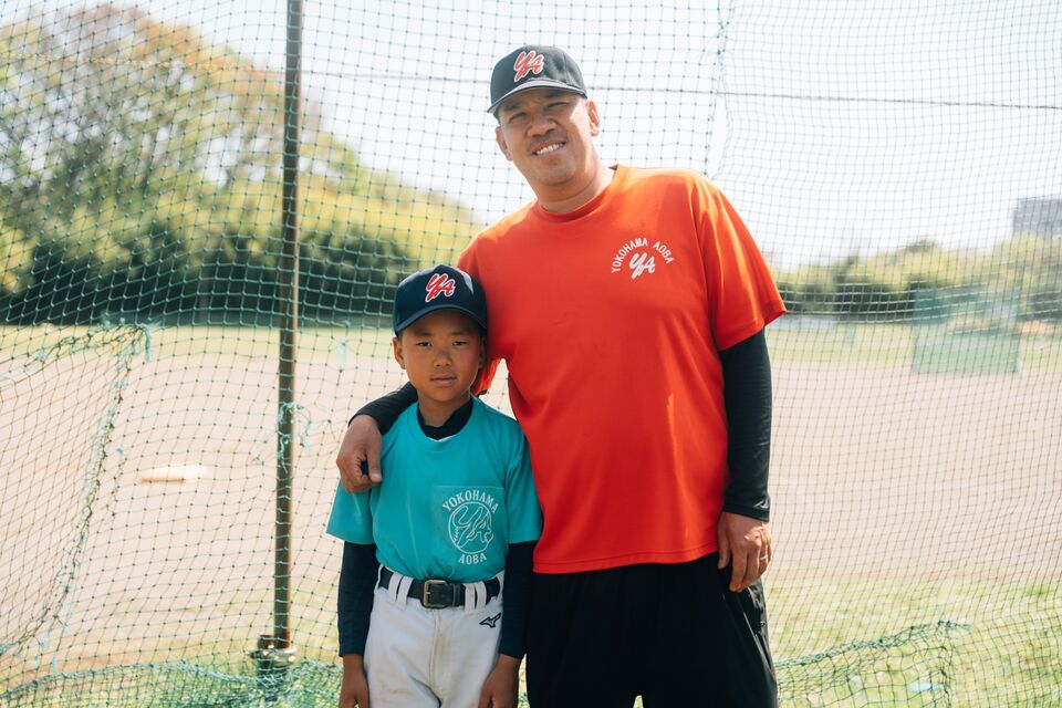 コーチと肩を組む低学年の選手